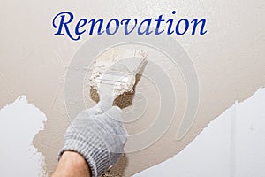 Paint brush, close up hand painter worker painting on surface wall Painting apartment, renovating with beige color paint