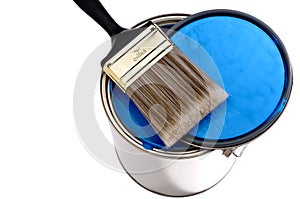 Paint brush and lid on a can of blue paint photo