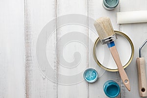 Paint, brush and other painting supplies on white wooden table