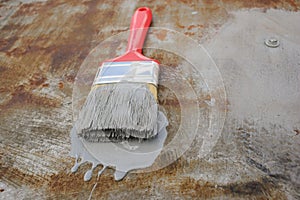 paint brush with paint on the rusty iron