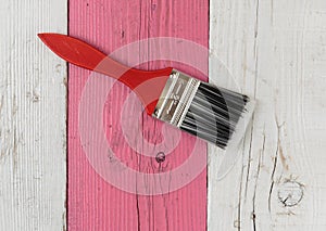 Paint brush and pink wooden board