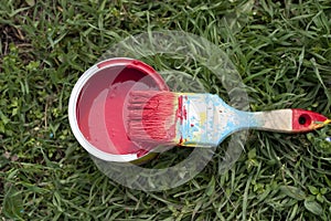 Paint brush and pot of red paint