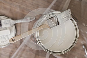 Paint brush resting on paint tin