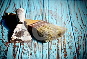 Paint Brush and Trowel scraping on the wood Table Paint by cyan color