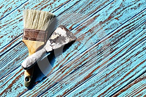Paint Brush and Trowel scraping on the wood Table Paint by cyan color