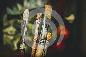 Paint brushes with dark painting on background. Artist work concept