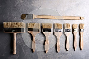 Paint brushes on a gray concrete background. Top view