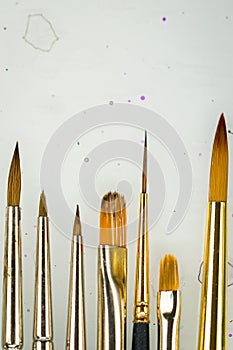 Paint brushes lined up on backdrop close up