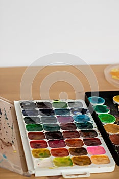 Paint brushes and watercolor paints,  tempera paints on the table in a workshop