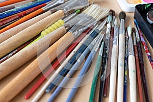 Paint brushes and watercolor paints,  tempera paints on the table in a workshop