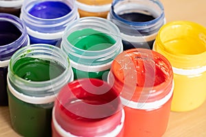 Paint brushes and watercolor paints,  tempera paints on the table in a workshop