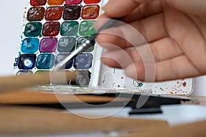 Paint brushes and watercolor paints,  tempera paints on the table in a workshop