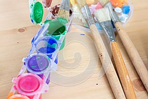 Paint brushes and watercolor paints,  tempera paints on the table in a workshop