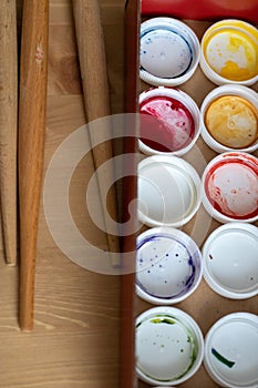 Paint brushes and watercolor paints,  tempera paints on the table in a workshop