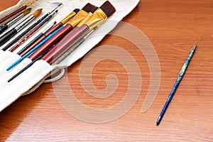 Paint brushes and watercolor paints, tempera paints on the table in a workshop