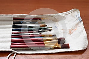 Paint brushes and watercolor paints, tempera paints on the table in a workshop