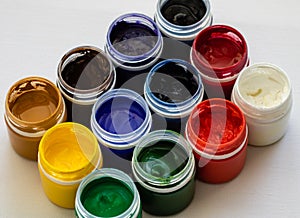 Paint brushes and watercolor paints, tempera paints on the table in a workshop