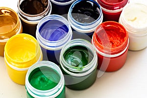 Paint brushes and watercolor paints, tempera paints on the table in a workshop