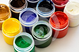 Paint brushes and watercolor paints, tempera paints on the table in a workshop