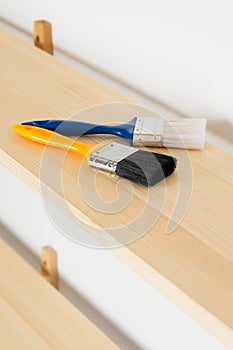 Paint brushes are on a wooden shelf