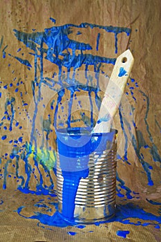 Paint can with brush and blue paint splatters photo