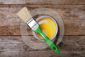 Paint can and brush on wooden background