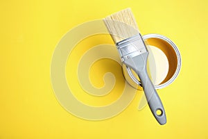 Paint can and brush on yellow background