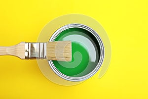 Paint can and brush on yellow background