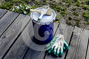 Paint can lying on the terrace of a private house with a brush and gloves, ready to be opened and painted. home repair and mainten photo