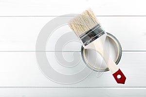 paint can with paintbrush on wooden background with copysp