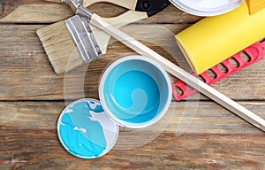 Paint can and tools on wooden background