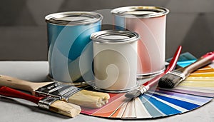 Paint cans, color palette samples and brushes on table