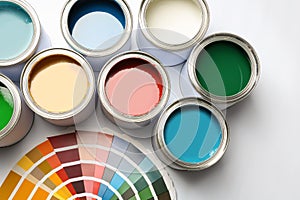 Paint cans and color palette on white background