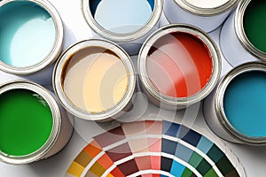 Paint cans and color palette on white background