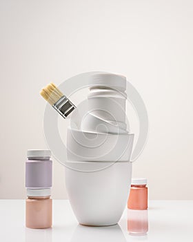 Paint cans, jars and a brush on a light background with copy space