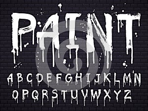 Paint dripping paint font for latin alphabet isolated on dark background with bricks. White oil letters