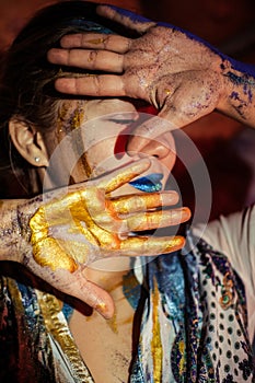 Paint on the face and body of a woman. A woman in the spotlight poses for the camera. Body art.