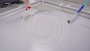 Paint the floor with white paint to protect the surface. Painting the floor with a roller white.
