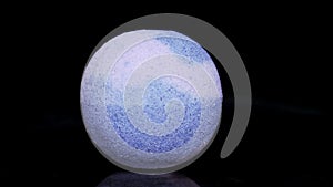 Paint flows down the surface of the texture ball. Sphere of coarse-grained salt rotates on a black background.