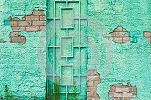 Paint green wall grill rustic old background.building green wall with a door metal grill.Closeup