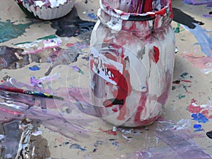 Paint jar and paints splattered on paper