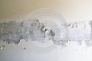 Paint peeling off the white concrete wall