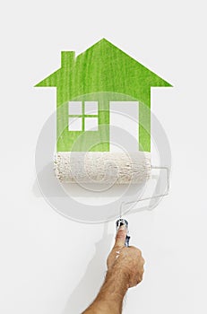 paint roller hand with green house symbol painting on wall isolated on white