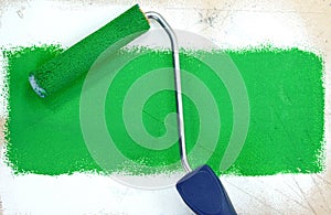 Paint roller leaving stroke of brown green over a white