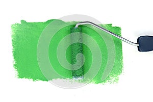 Paint roller leaving stroke of brown green over a white