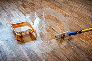 Paint roller and varnish, renovation of old wooden parquet