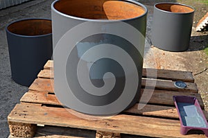 Paint rusty flower pots in the shape of a cylinder. gray color is applied using a brush and a foam roller. ball painter soaked too