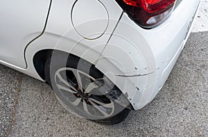 Paint scratches on a bumper of the white car