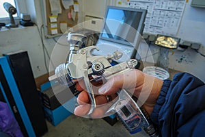 a paint spray gun is held in the hand