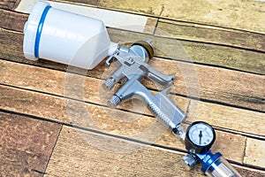 Paint spray on wooden floors Image of the painter`s arm hand holding industrial size spray gun used for industrial painting and c